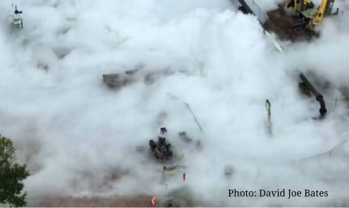 A fog of smoke billows over and obscures construction equipment