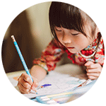 Child writing on paper with pencil