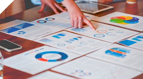 Sheets of paper with colorful graphs and charts laid out on a desk