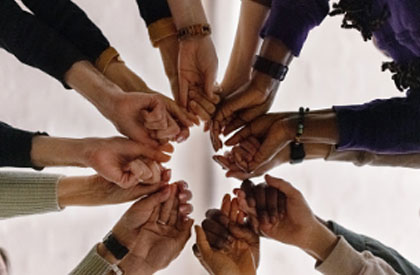 People's hands joined together in a circle