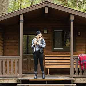 Family sitting outside RV around campfire