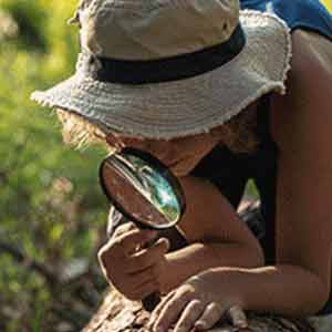 Child looking through magnifying glass 